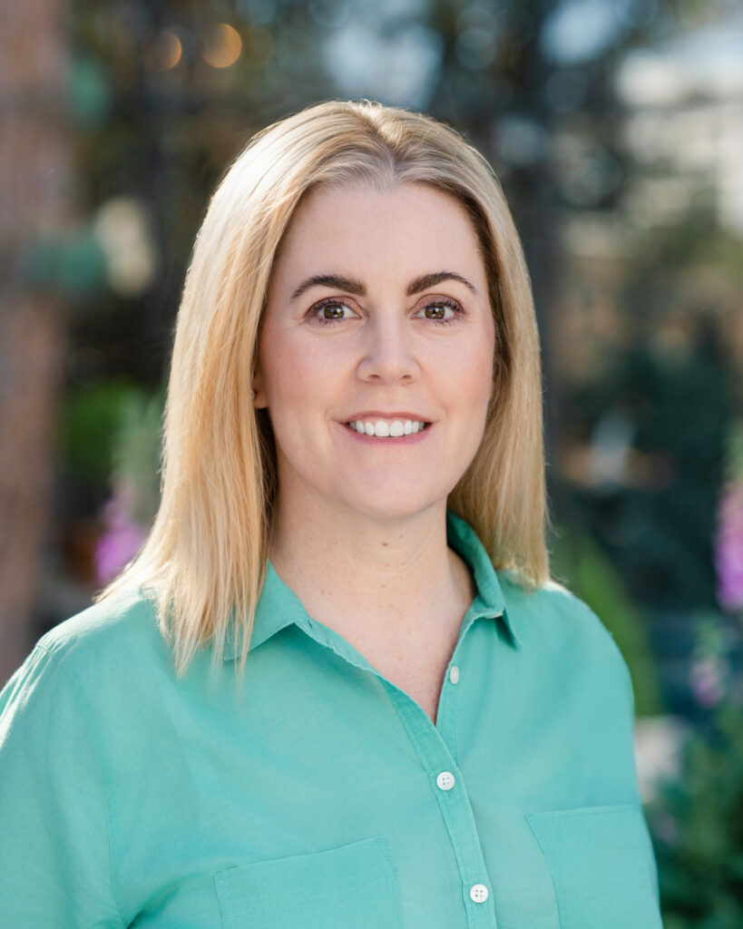 Professional outdoor headshot of an individual taken at Roger’s Garden in Newport Beach, CA by Art of Portraits photographer, featuring natural light and a garden background.
